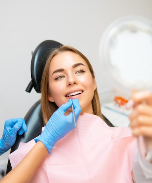 woman-examines-her-radiant-smile-mirror-after-teeth-whitening